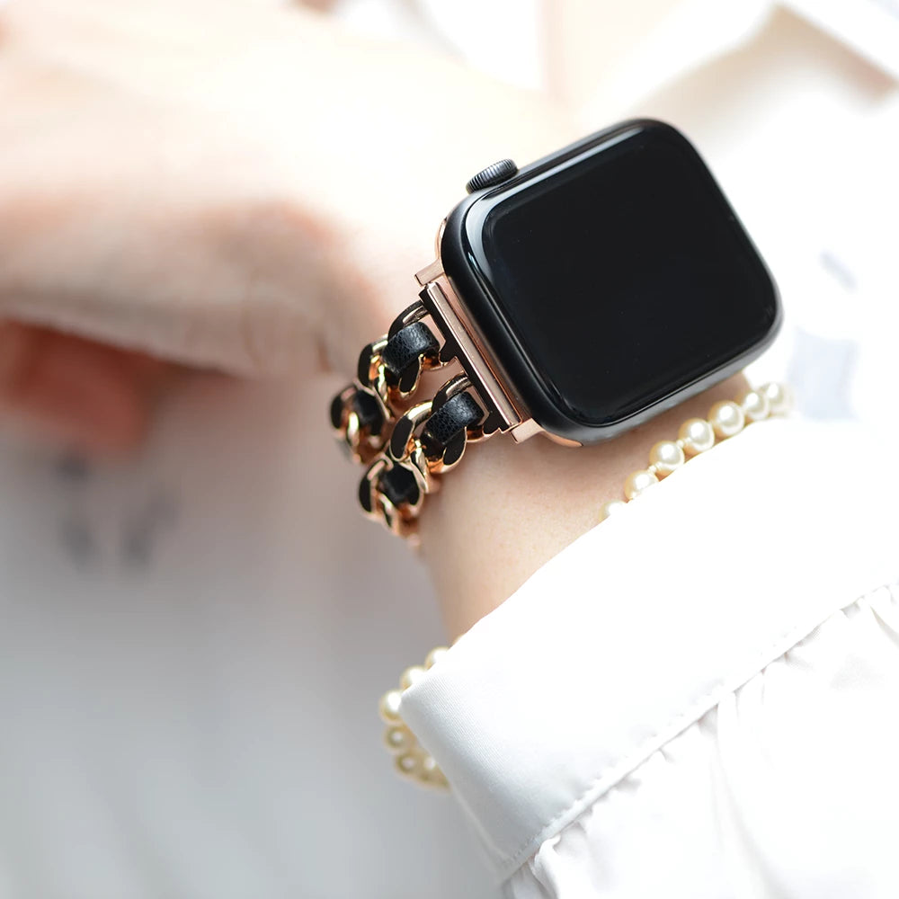 Apple Watch Kettenarmband aus Metall, Hochglanzkette und Leder, Farbe Rose Gold und Schwarz, Glamour und Luxus Style, Modell: Modena, Ansicht am Handgelenk einer Dame mit weißer Bluse und Perlenarmkette - MONTENY