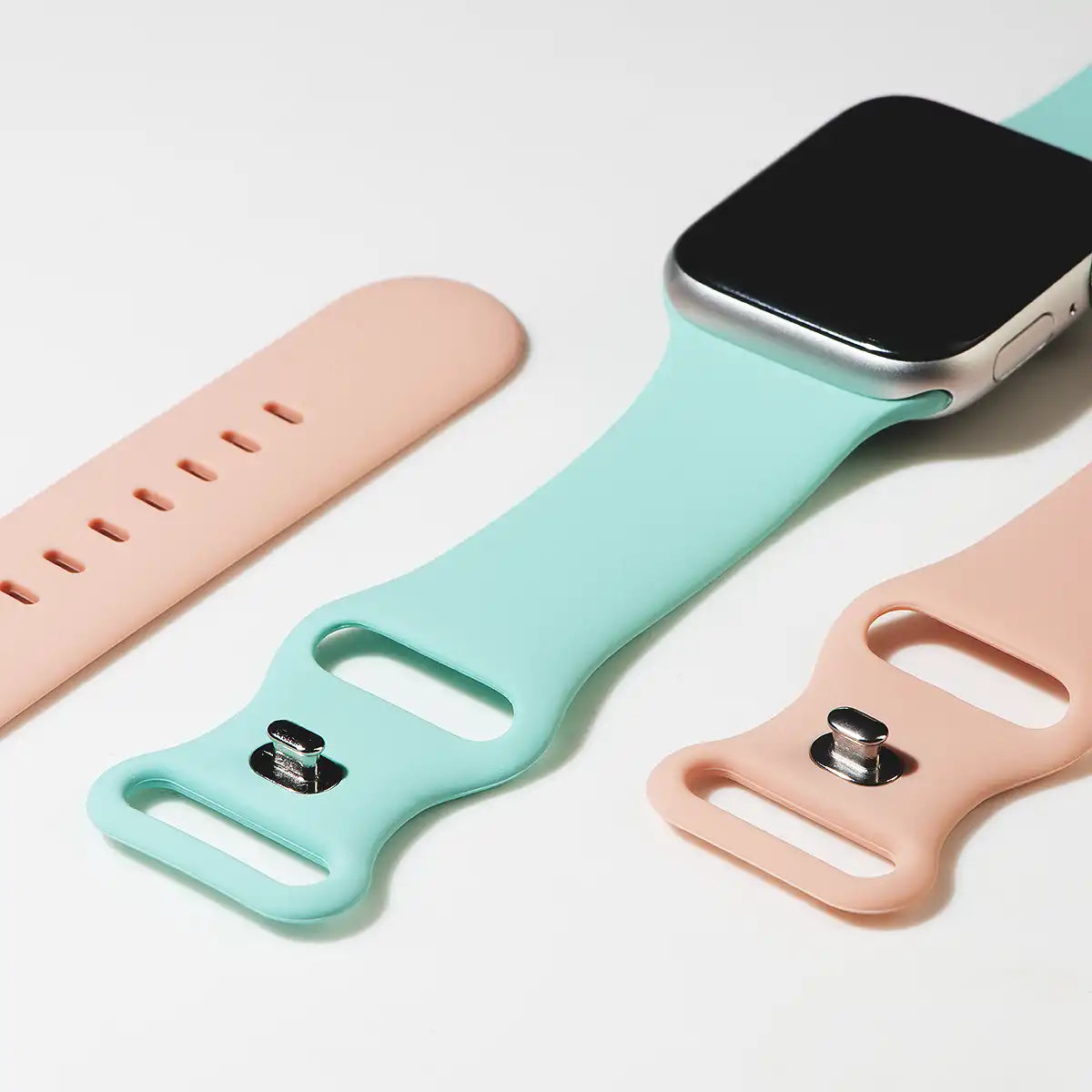 apple watch silikon armband rosa und tuerkis liegend auf tisch von der Seite offen malta monteny