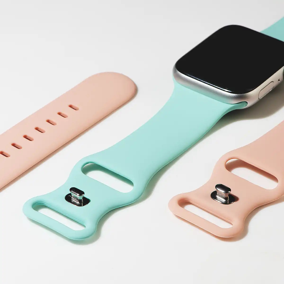 apple watch silikon armband rosa und  tuerkis liegend auf tisch von der Seite offen malta monteny